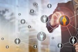 Business professional analyzing a digital network of people icons, representing strategic talent mapping and workforce connection in a corporate environment