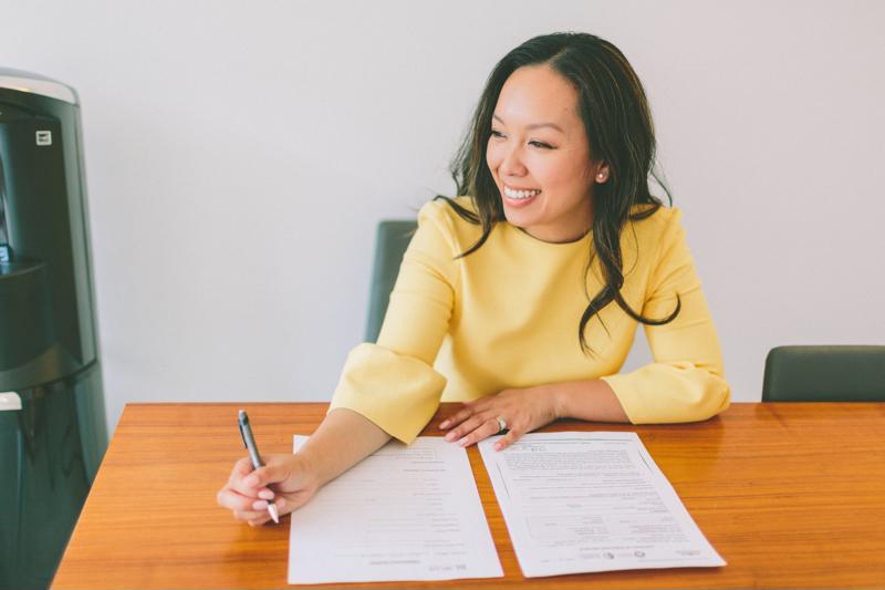 A businesswoman reviews a resume at her desk.