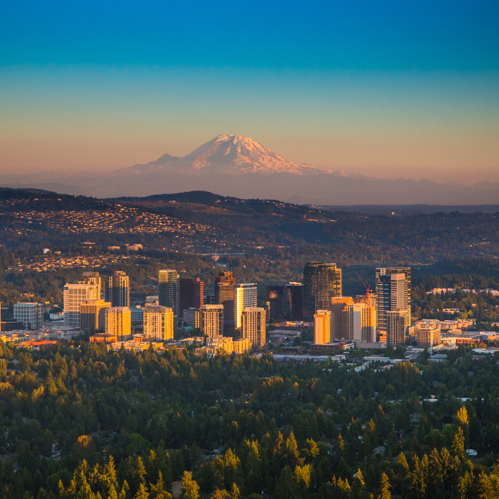 Aerial view of downtown Bellevue, Washington, at sunset with Mount Rainier in the background.