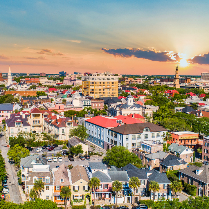Aerial view of Charleston, SC at sunset with colorful historic homes and church steeples, representing a vibrant business and staffing community.