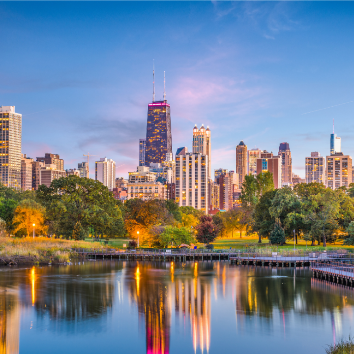 A stunning evening view of downtown Chicago from Lincoln Park, with high-rise buildings reflecting in a peaceful pond—representing the western neighborhoods and business districts served by temp staffing and consulting experts.