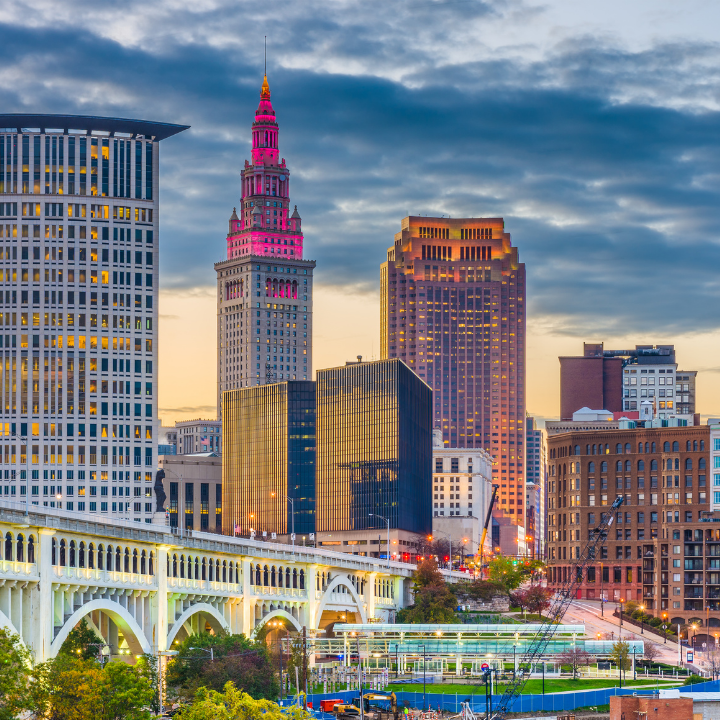 A colorful view of the downtown Cleveland skyline at sunset, featuring iconic architecture and a prominent bridge in the foreground—capturing the city’s innovation and growth in tech staffing and consulting.