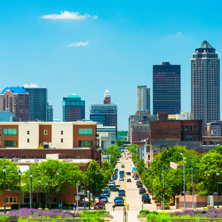 Downtown Des Moines, Iowa skyline with a clear blue sky and bustling city streets, symbolizing a thriving hub for temp agencies and employment opportunities.