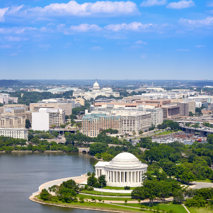Aerial view of Washington, DC featuring the Jefferson Memorial, U.S. Capitol, and federal buildings surrounded by greenery and the Potomac River—illustrating the hub of DC government jobs and tailored staffing solutions.